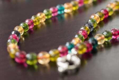 Necklace from glass beads of different colors on a dark surface close upの写真素材
