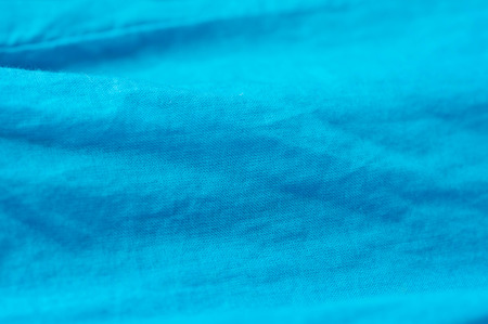 The crumpled textile background of turquoise colorの写真素材