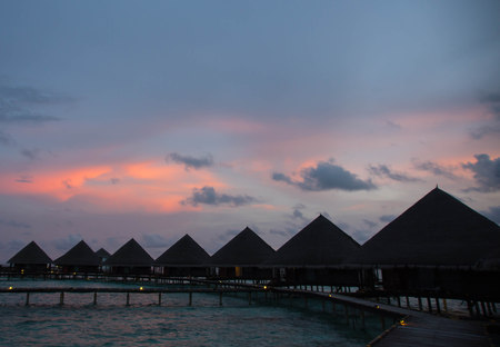 Sunset in the Maldives with a view of the ocean, sky and bungalowsのeditorial素材