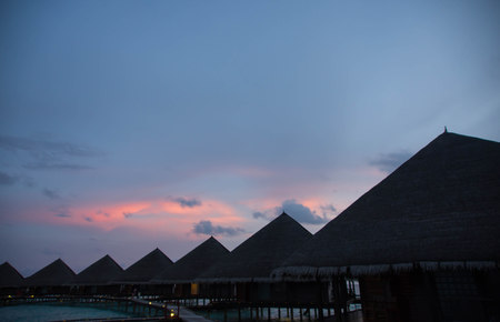 Sunset in the Maldives with a view of the ocean, sky and bungalowsのeditorial素材