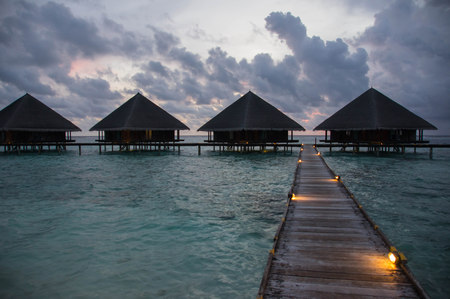 Sunset in the Maldives with a view of the ocean, sky and bungalowsのeditorial素材