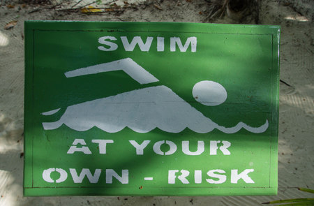 The sign saysÂ "Swim at your own risk"の写真素材