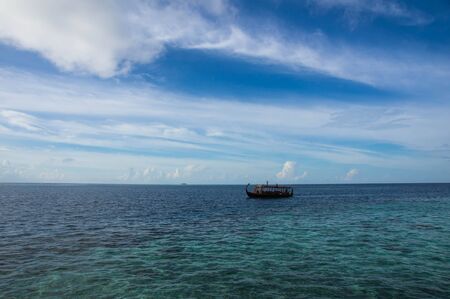 Boat floating on the ocean on a cloudy dayの写真素材
