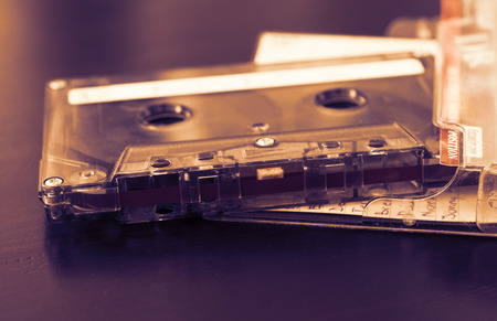 Old audio cassette on a dark wooden background close upの写真素材