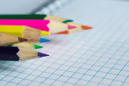 Pencils of different colors on an open notebook