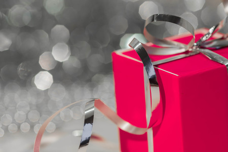 Red gift box on the background of silvery tinselの写真素材