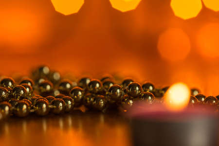 Burning candle and Christmas ornaments with bokeh in the backgroundの写真素材