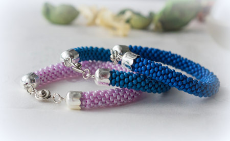Three crochet bracelet from large beads on the textile background