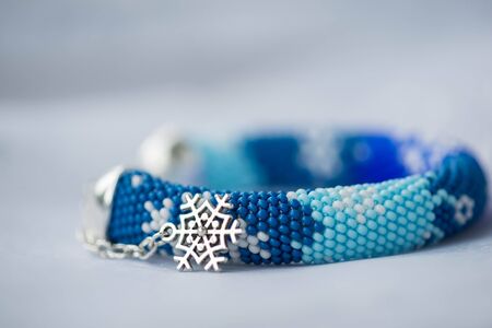 Handmade beaded bracelet with the image of snowflakesの写真素材