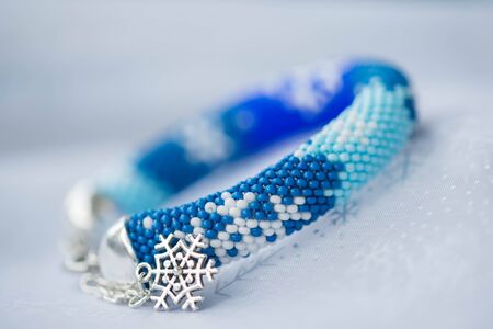 Handmade beaded bracelet with the image of snowflakesの写真素材