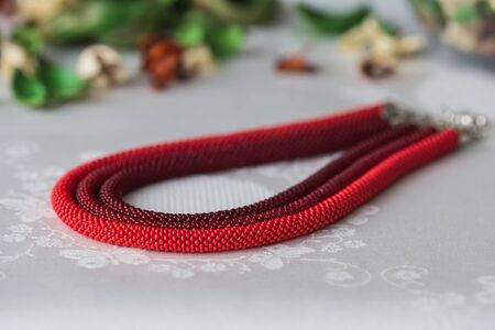 Beaded necklace of red color from three ropesの写真素材
