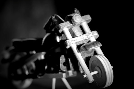 Wooden toy motorcycle on a dark background. Black and white