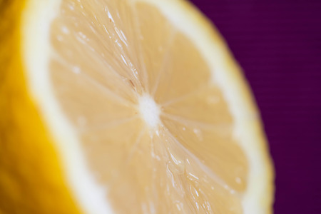 Half of lemon on a crimson background close upの写真素材