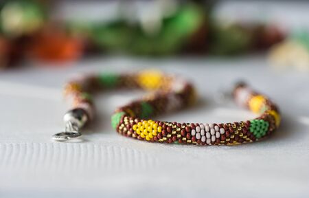 Crochet beaded necklace with rhombus pattern of the textile backgroundの写真素材