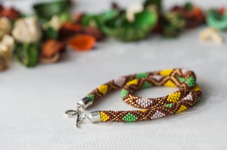 Crochet beaded necklace with rhombus pattern of the textile backgroundの写真素材