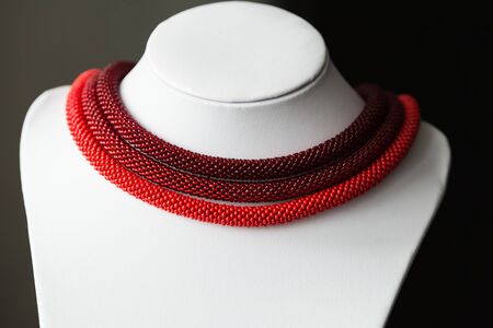 Beaded necklace of red color from three ropesの写真素材