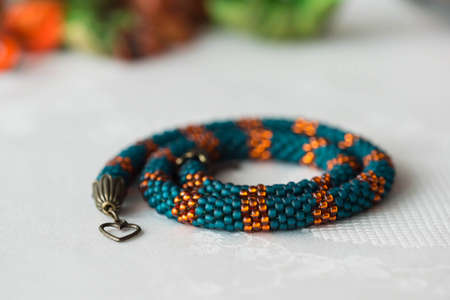 Handmade necklace from beads of emerald and orange colorの写真素材