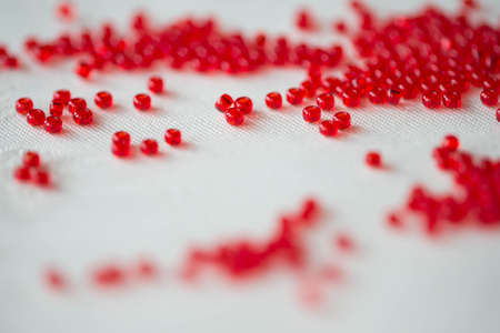 Seed beads of dark red color on the textile background close upの写真素材