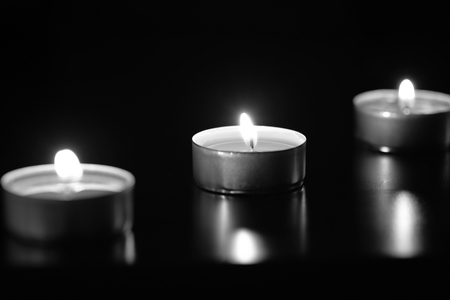Some burning candles in the dark, black and whiteの写真素材