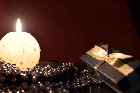 Burning candle, gift box and Christmas decorationsの写真素材