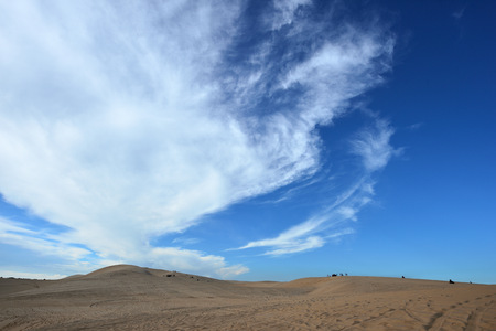 Blue cloudy sky over sand dunes in the eveningの写真素材