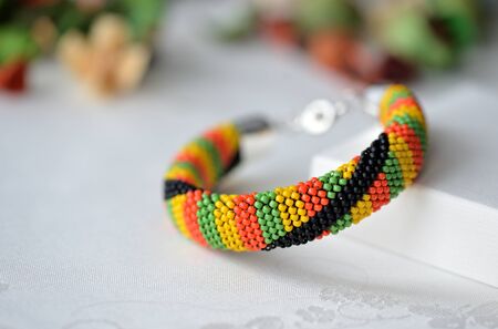 Colorful beaded crocheted bracelet on textile backgroundの写真素材