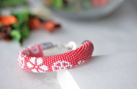 Red beaded crocheted bracelet with floral printの写真素材