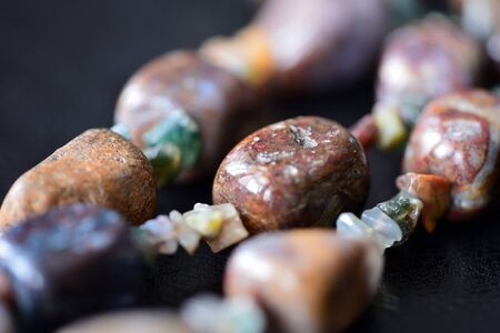 Fragment of stone necklace on a dark surface close upの写真素材