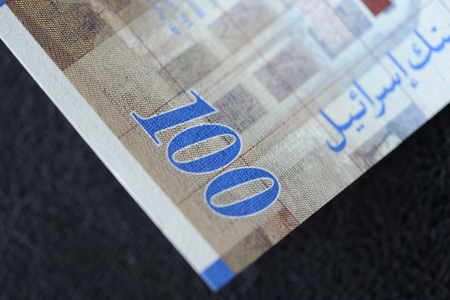 Israeli banknote hundred shekels on a dark background close up