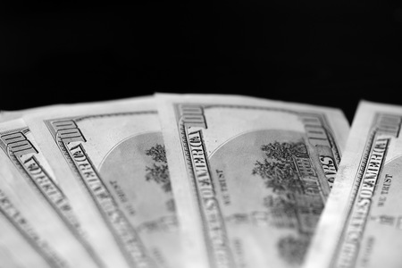 Hundred dollar bills on a dark background close up, black and whiteの写真素材