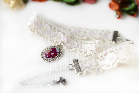Lace choker with a pendant made of epoxy resin and rose petalsの写真素材