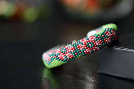 Green beaded bracelet with floral print on a dark backgroundの写真素材