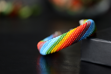 Bead crocheted bracelet of a rainbow colors on a dark backgroundの写真素材