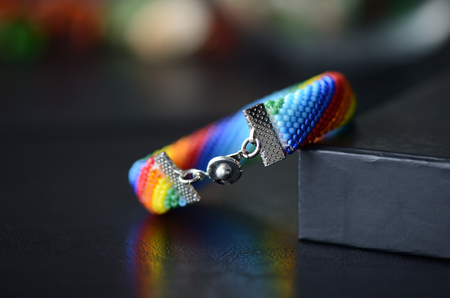 Handmade crocheted bracelet rainbow colors on a dark backgroundの写真素材
