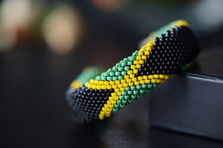 Jamaican flag bead crochet bracelet on a dark bakgroundの写真素材