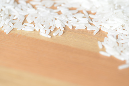 Scattered rice grains on the wooden surfaceの写真素材