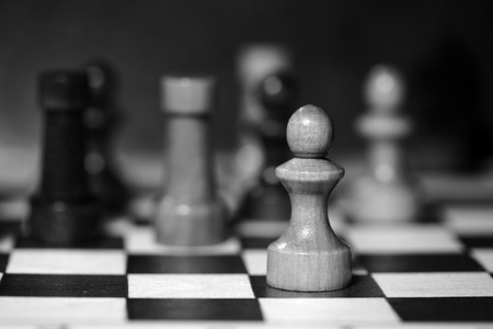 Chess figures on a chessboard in black and whiteの写真素材