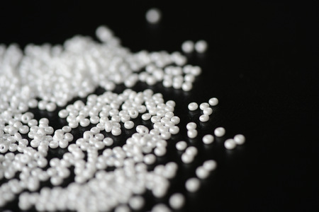 White seed beads scattered on a dark backgroundの写真素材