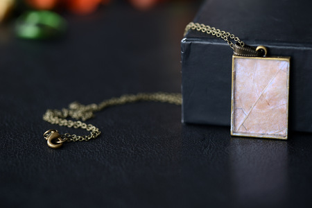 Maple leaf pendant on a dark background close upの写真素材