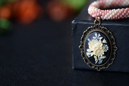 Short beaded choker with rose cameo on a dark background close upの写真素材