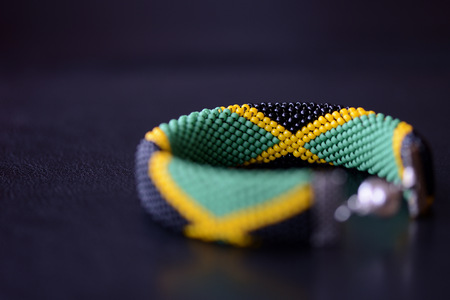 Seed beads bracelet Jamaican flag on a dark background close upの写真素材