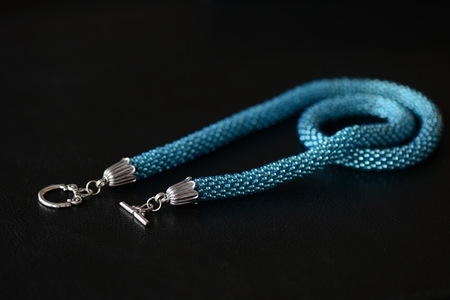 Beaded necklace of turquoise color on a dark background close upの写真素材