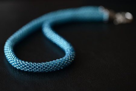 Beaded necklace of turquoise color on a dark background close upの写真素材