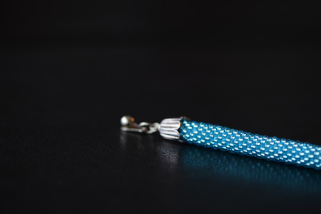 Beaded bracelet of turquoise color on a dark background close upの写真素材