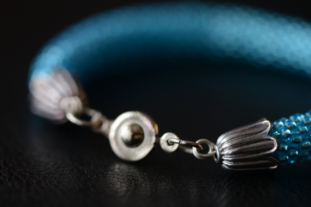 Beaded bracelet of turquoise color on a dark background close upの写真素材