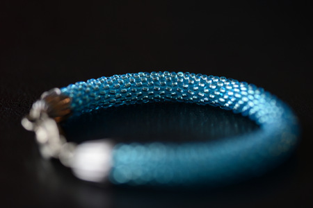 Beaded bracelet of turquoise color on a dark background close upの写真素材