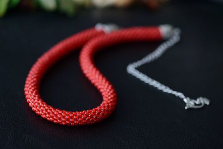 Red bead crochet necklace a dark background close upの写真素材