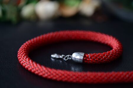 Red bead crochet necklace a dark background close upの写真素材
