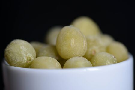 Frozen gooseberries on a dark background close upの写真素材