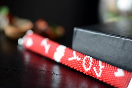 Red beaded I Love You bracelet on a dark background close upの写真素材